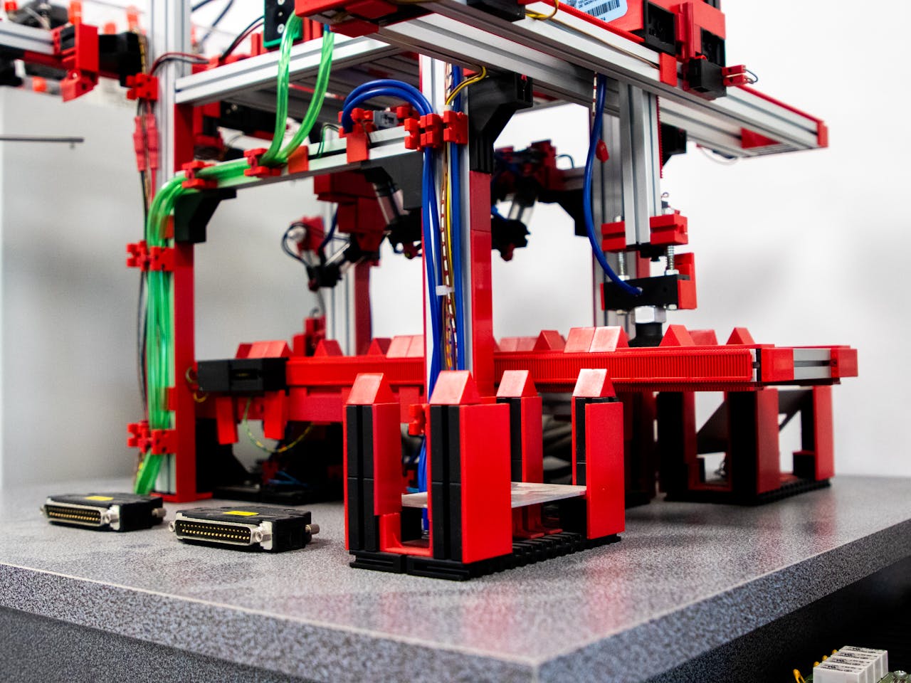 Close-up view of a robotic assembly machine with vibrant red and metallic components.