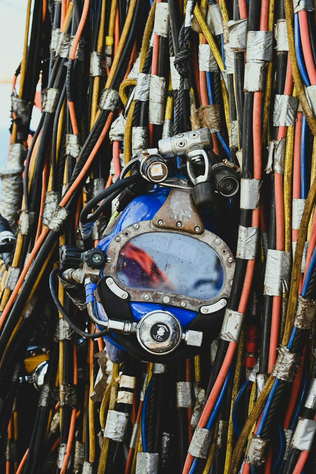 vintage-diving-helmet-amidst-tangled-cables-txgxk1j72wu